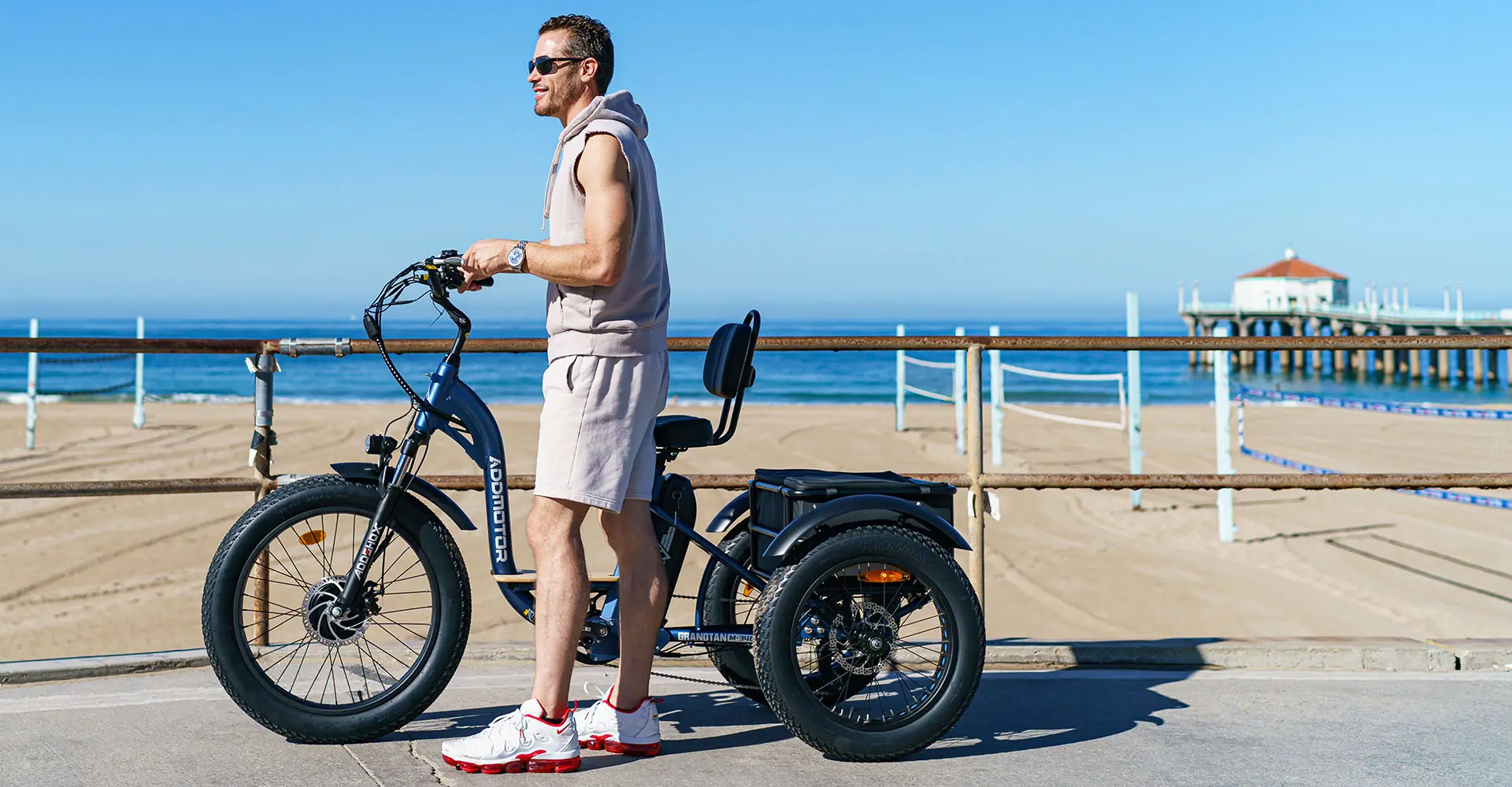 a man riding grandtan tricycle around the beaches