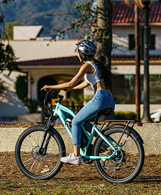 a woman with a black helmet is riding a citypro ebike in cyan green