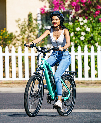 a woman with a black helmet is smiling a citypro ebike in cyan green