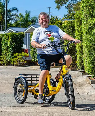 A fat senior riding his citytri electric trike in the city