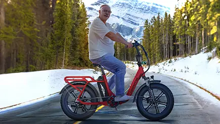senior riding a Foldtan m-120 ebike in the mountain in winter-