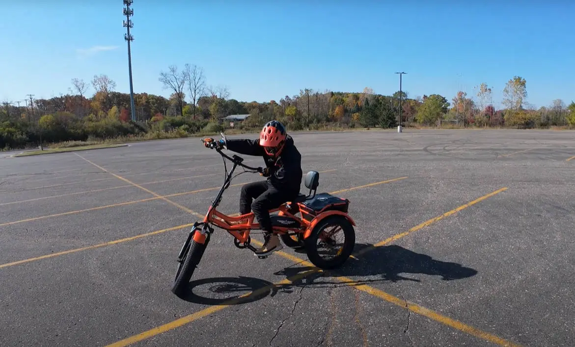 The reviewer is testing the turning performance of the M-360 electric tricycle