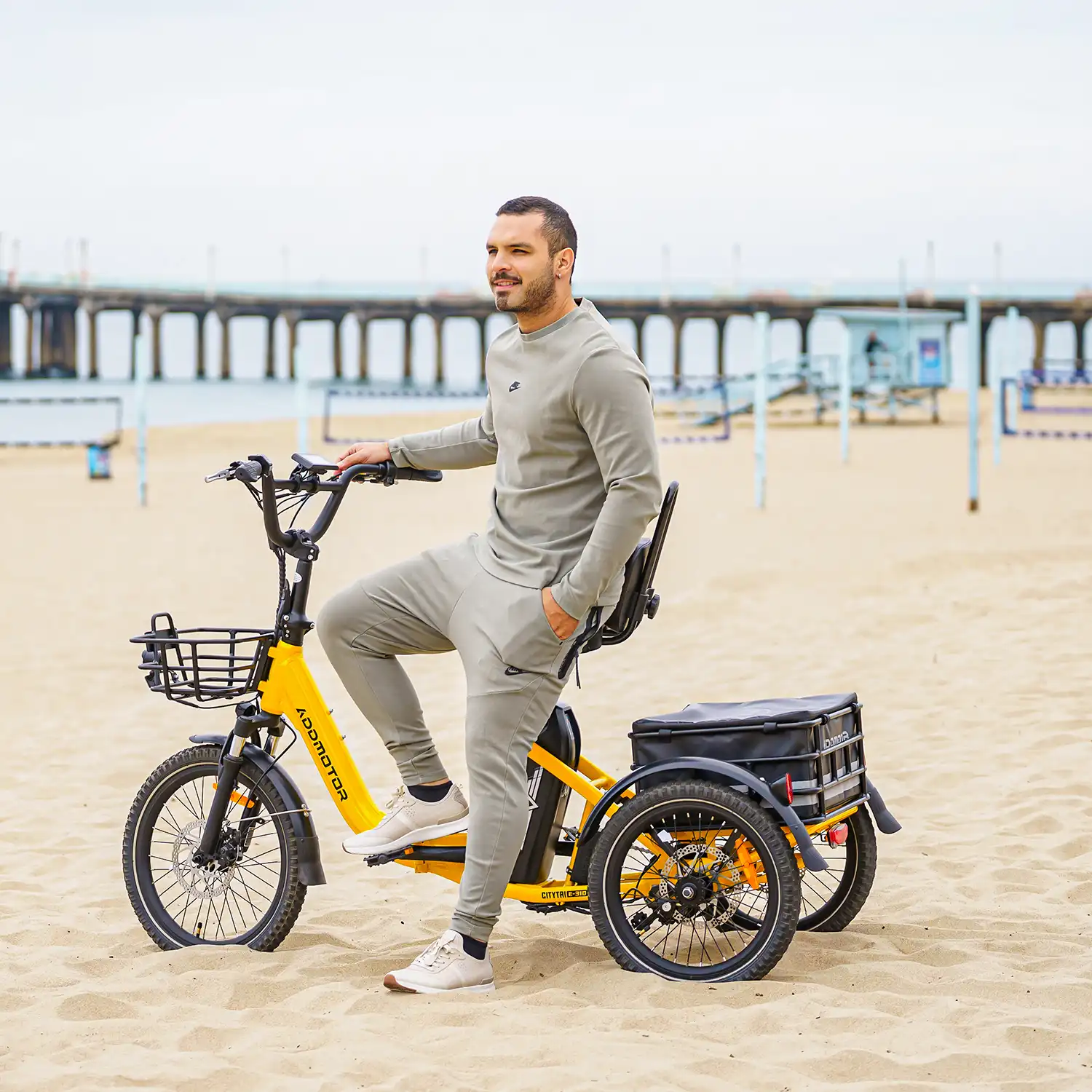a man is riding Addmotor E-310 trike on the beach