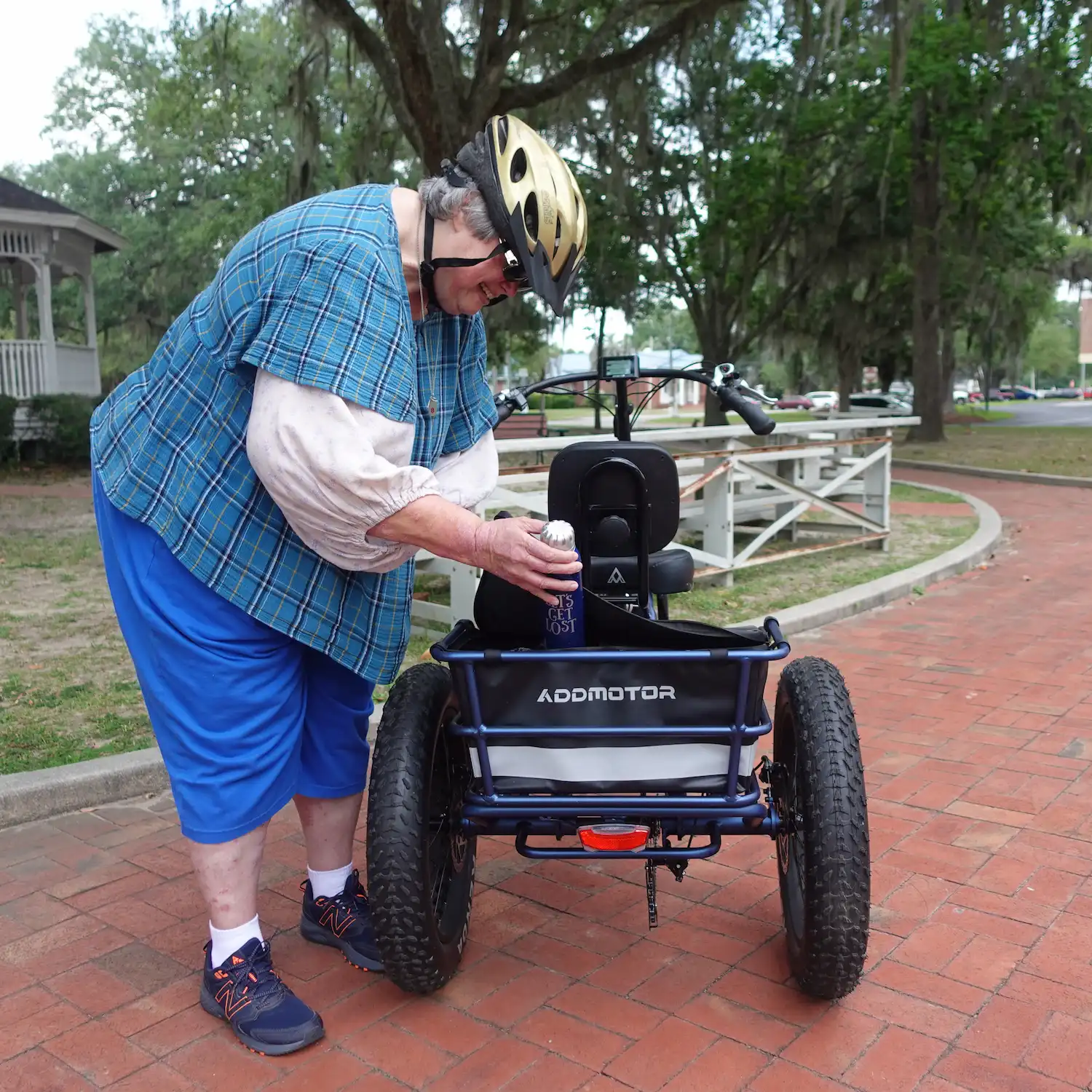 A woman is putting things to the rear basket of Addmotor Etrike M-360