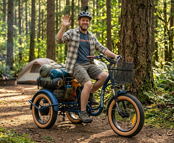Fat tire electric trike with an 80mm front suspension fork gliding over gravel and rough terrain.