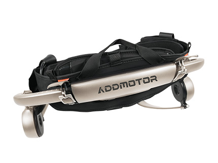 Side-by-side view showing folded portable exoskeleton next to a 10-inch laptop slipping into hard-shell storage bag