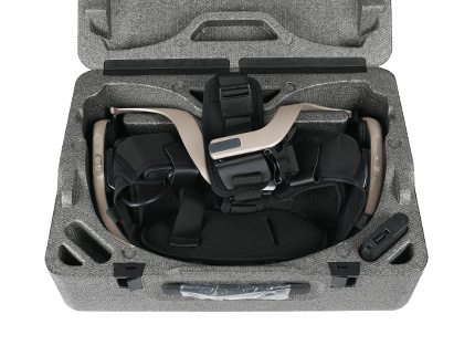 Side-by-side view showing folded portable exoskeleton next to a 10-inch laptop slipping into hard-shell storage bag